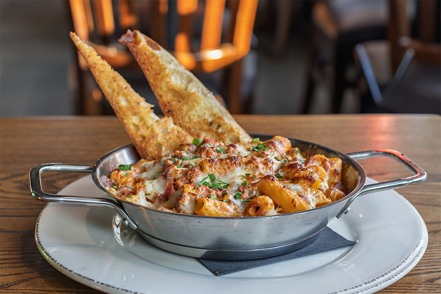 Spicy Rigatoni with sausage, mozzarella cheese, parmesan cheese, and spicy tomato cream sauce with garlic toast points on the side