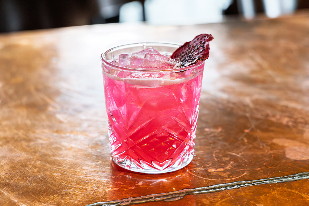 Dragon's Breath is made with blanco tequila, pelotón de la muerte mezcal, yuzu curaçao, dragon fruit, and lime