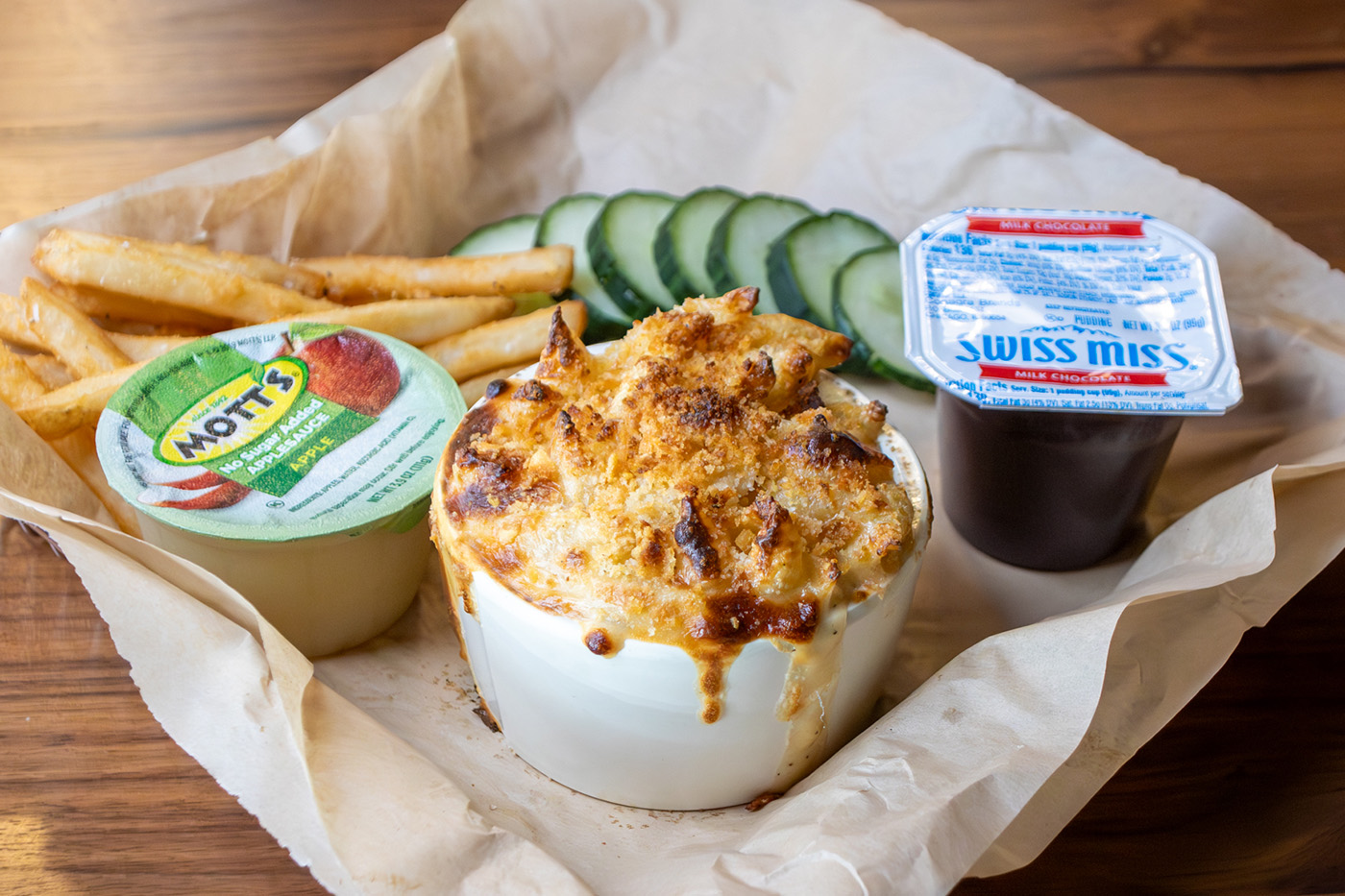 Kids Meal with mac and cheese, side of sliced cucumbers, apple sauce, fries and a pudding cup
