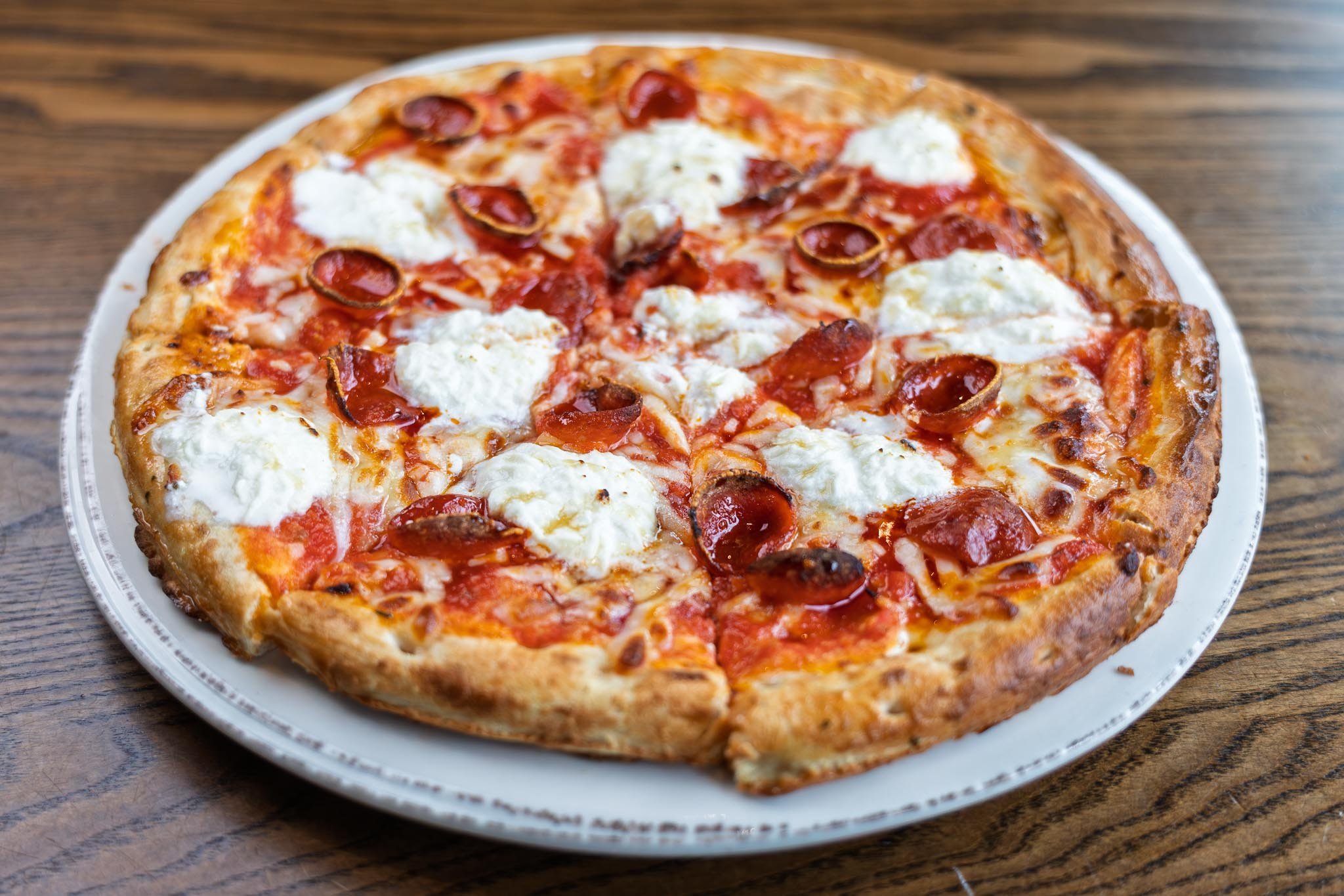 Pepperoni ricotta and hot honey pizza made with cup & char pepperoni, fresh ricotta, house-made tomato sauce, hot honey drizzle. Gluten free crust available